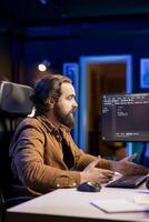 Computer scientist securing company servers from cyberattacks to avoid unwanted failures. IT admin in living room writing code to build firewalls protecting data from threats photo