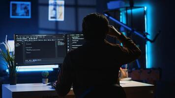 Man doing IT support job from apartment personal office drinking cup of coffee while coding. Software developer enjoying hot beverage and writing lines of code on computer, camera A photo