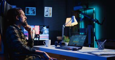 Remotely working company financial advisor analyzing statistical graphs on laptop screen at home. Freelancer using electronic device to compare business revenue numbers in apartment office, camera B photo