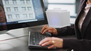 Skilled designer using 3D modeling tools to develop designs for buildings, create architectural plans at desk. Woman performing engineering task with CAD software app in a startup office. photo