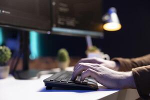 Programmer typing on keyboard, implementing and maintaining security measures to protect company systems and data. Expert writing, testing and debugging Java code for software applications, close up photo