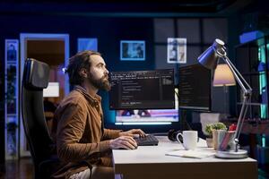 Programmer working from home securing company servers from DDoS attacks to avoid unwanted breakdowns. Expert writing code to build advanced firewalls protecting data from potential threats photo