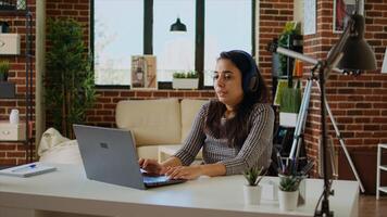 Prospecting job candidate remotely being interviewed via online videocall. Woman wearing headphones answering HR interview questions during videoconference meeting while staying at home, camera A photo