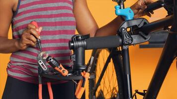 Close up shot of worker preparing work tools before starting refurbishing malfunctioning bicycle, studio background. Expert arranging screwdriver, pliers and hex wrench on equipment support, camera A photo
