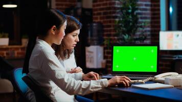 Manager and company financial advisor analyzing statistical graphs on green screen laptop. Management executive and worker comparing business revenue numbers on chroma key device photo