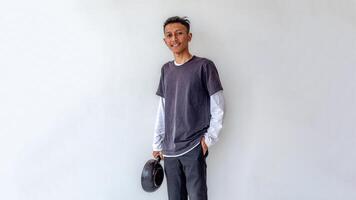 a young man standing proudly while holding a frying pan like a chef isolated on white background photo