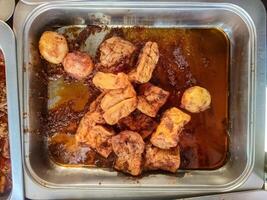 A traditional Balinese dish of deep fried tofu and hard boiled eggs simmered in a rich and spicy sauce. photo