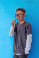 a young man wearing a gray t-shirt smoking isolated on blue background. suitable for health and environmental concepts photo