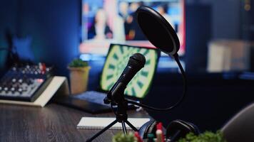 Close up shot of podcast microphone used to record conversations for internet livestreaming show. Streaming sound capturing and recording technology in empty home studio with neon lights photo