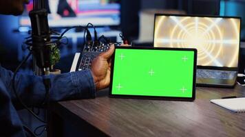 Man invited to podcast watching internet clips on green screen tablet with host in living room studio. Guest and presenter reacting to videos on mockup device during online comedy show, close up photo