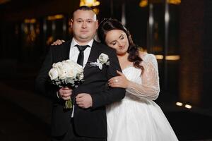 A man and woman are posing for a picture, the man is holding a bouquet of flowers photo