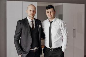 Two men in suits and ties pose for a photo. Scene is professional and formal photo