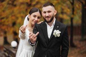 A bride and groom are posing for a picture with their hands up in the air, one of them giving a thumbs up photo