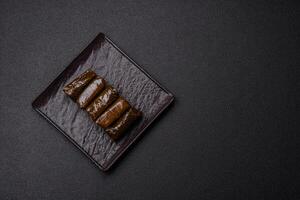 Delicious dolma in the form of rice and meat wrapped in grape leaves photo