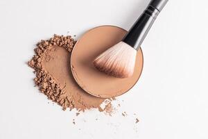 A sample of a round block of compact powder in a brown tone and a chic brush for applying makeup. loose powder sample. top view. layout for design. photo
