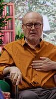 Vertical Nurse jumping to help senior man in wheelchair losing conscience during home visit, old person hyperventilating and scaring his wife. Medical assistant in panic checking the pulse. Camera A. video