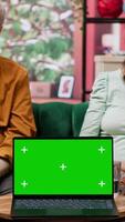 Vertical Caregiver nurse consulting senior couple next to chroma key mockup display on laptop, discussing about medical treatment and prescription. Specialist offering support and assistance. Camera A. video