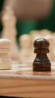 Vertical Happy senior people playing chess in a cozy home setting, thinking about strategy moves during board game leisure activity. Enjoyment of strategic intellectual hobby, mastermind pastime. Camera A. video
