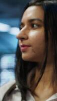 Vertical Engineer in high tech data center managing and maintaining databases, ensuring data integrity, security and availability. Indian woman updating server room supercomputers systems, camera A video