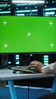 Vertical Engineer in server hub using green screen PC to stop hacker passing company firewall and stealing sensitive user data. Worker looking at mockup computer, seeing security breach notification, camera A video