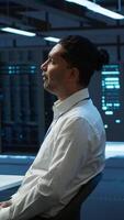 Vertical Admin in data center using augmented reality technology to ensure system can handle networking tasks. Server room worker looking at AR visualization hologram, tracking network traffic, camera A video