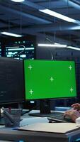 Vertical System administrator overseeing data center using green screen computer, ensuring system can handle networking tasks. IT expert in server room tracking network traffic with mockup PC, camera B video