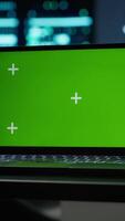 Vertical Focus on green screen laptop used by engineers in high tech data center to monitor security threats. Close up of mockup notebook used by workers ensuring compliance with regulations, camera A video