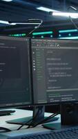 Vertical Computer displays in modern data center used for monitoring security threats threatening rigs. Panning shot of PCs used by high tech facility admins ensuring compliance with regulations video