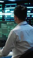 Vertical Engineer in server hub frightened by hacker passing company firewall and stealing sensitive user data. Afraid man panicks after seeing security breach notification on computer in data center, camera A video