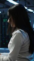 Vertical Portrait of smiling engineer overseeing data center, making improvements and updates to ensure system can handle networking tasks. Upbeat server room worker tracking network traffic, camera A video