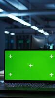 Vertical Focus on isolated screen laptop used by engineers in high tech data center to monitor security threats. Close up of chroma key notebook used by workers ensuring compliance with regulations video