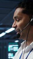 Vertical System administrator in data center managing and maintaining databases, ensuring data integrity, security and availability. Indian man updating server farm supercomputers systems, camera B video