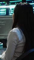 Vertical Team of technicians in data center designing, implementing and managing infrastructure to ensure optimal performance and reliability. Teamworking colleagues in server room coding on computer, camera A video