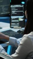 Vertical Person with paraplegia working in inclusive server hub workspace, typing on PC. Woman in wheelchair doing tasks in data center housing advanced data storage infrastructure, camera A video