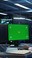 Vertical Engineer in data center monitoring security threats using mockup computer, implementing cybersecurity measures. Man using green screen PC, ensuring compliance with regulations, camera B video