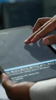 Vertical Data center admin responsible for installation of networking systems solving tasks in workspace. Close up of tablet used by IT worker doing maintenance on server farm gear, camera A video