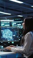 Vertical Team of engineers using AI tech on computer to do checkup in server room. Data center workers using artificial intelligence technology to process datasets for training, camera B video