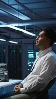 Vertical Admin in data center using augmented reality technology to ensure system can handle networking tasks. Server room worker looking at AR visualization hologram, tracking network traffic, camera B video
