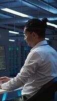 Vertical Data center technician responsible for installation and repair of networking equipment solving tasks. IT specialist doing maintenance on server room infrastructure, camera B video