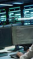 Vertical Coworkers in high tech data center monitoring security threats, implementing cybersecurity measures. IT staff members ensuring compliance with server room workspace regulations video