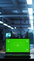 Vertical Focus on mockup laptop used by technician in data center in blurry background managing servers. Close up of chroma key notebook used by expert in server hub to ensure networks are secure, camera B video