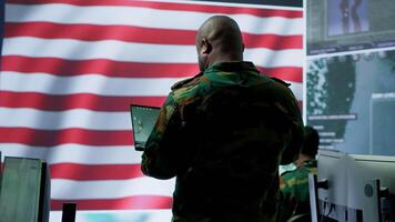 Team of military experts operates high tech computers and tablet to analyze surveillance data and manage national security operations. Working with CCTV radar satellite imagery. Camera A. video