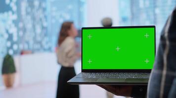 Realtors and client evaluating blueprints next to green screen display, working on new high class office space layout development. Businesswoman sharing her interior design vision. Camera B. video
