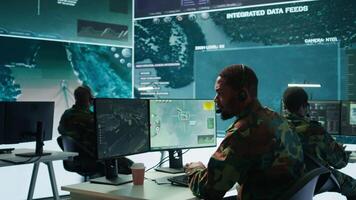 Soldiers in a state of the art military control room collaborate on data analysis, intelligence gathering, and mission planning. Ensure effectiveness and security of military operations. Camera B. video