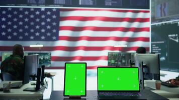 US military working in a control center with isolated mockup, soldiers examining satellite footage for clues regarding security protocols. American army command post for surveillance. Camera B. video