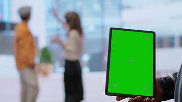 Real estate agents and client examine blueprints next to a green screen, working together on new modern office space development layout. Sharing workspace design vision. Camera B. video