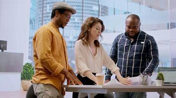 During an office tour, professional clients and realtor review blueprints and discuss investment strategy for modern workspace development. Strategizes layout of new urban office space. Camera A. video