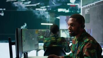 Army intelligence specialist utilize advanced computer systems, surveillance technology and data to enhance national security. Working in a command post against potential threats. Camera B. video
