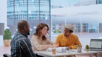 During an office tour, professional clients and realtor review blueprints and discuss investment strategy for modern workspace development. Strategizes layout of new urban office space. Camera B. video
