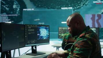 Machine learning specialist monitors satellite data and neural network to collect data for operations. Programming algorithms for cybersecurity and national safety, AI brain visualization. Camera B. video